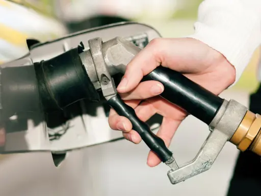 Dłoń trzymająca pistolet do tankowania, gotowa do nalania gazu do diesla.