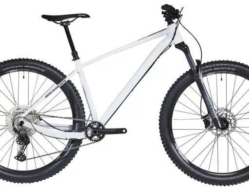 Biały rower hardtail z czarnymi oponami i amortyzatorem RockShox. Idealny na górskie trasy.