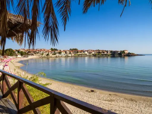 Widok na zatokę z piaszczystą plażą i miasteczkiem w tle. Czy to złote piaski, czy słoneczny brzeg?