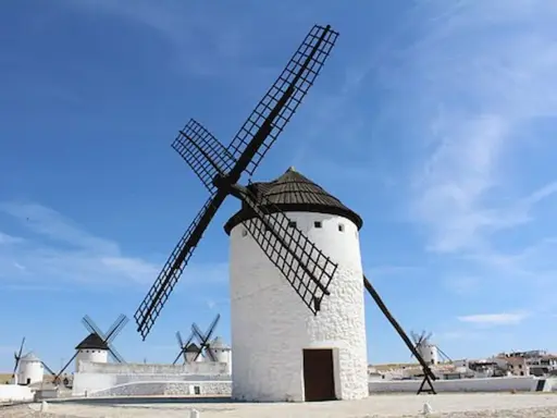 Molinos de viento blancos bajo un cielo azul. Un lugar que ver en Ciudad Real, como sacado de un cuento.