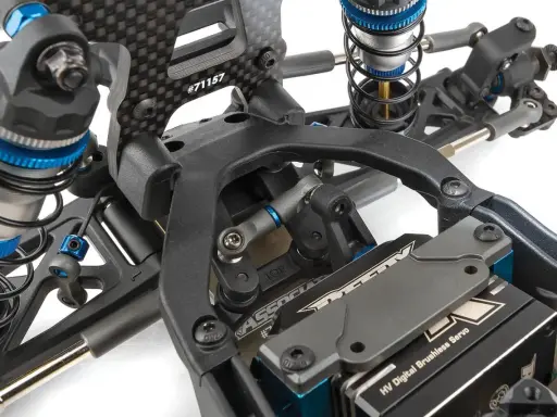 Detailaufnahme des Fahrwerks eines RC-Autos. Stoßdämpfer, Carbonteile und ein HV Digital Brushless Servo sind sichtbar. Die Nummer #71157 ist auf einem Teil eingraviert.