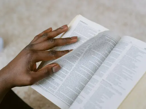 Dłoń przewracająca strony Biblii, szukająca pocieszenia w Psalmie 27.