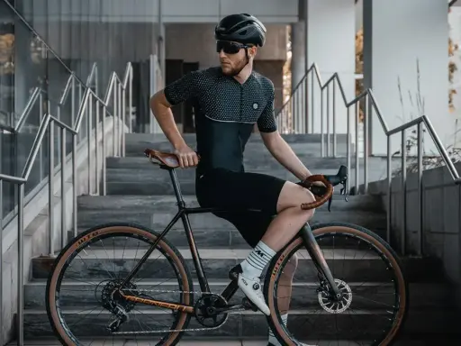 Mężczyzna w stroju kolarskim siedzi na rowerze z ramą 48 cm, idealną dla osób o wzroście ok. 170-175 cm.