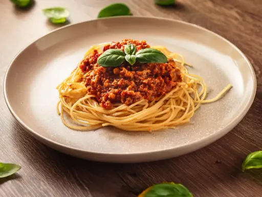 Pyszne spaghetti bolognese, idealne na prosty obiad. Aromatyczny sos mięsny z pomidorami i świeża bazylia.