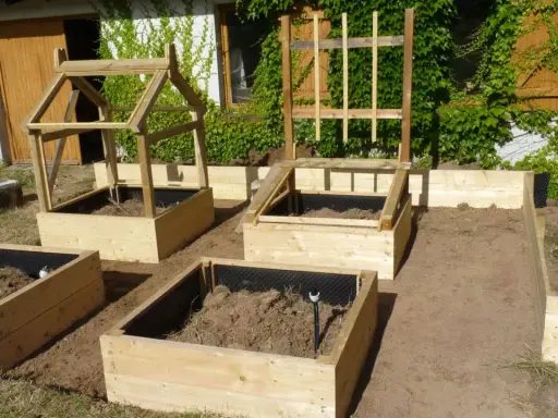 Nouveau potager en carré prêt à être planté. Structures en bois pour protéger les futures cultures.