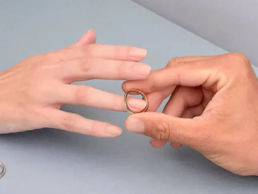 Manos unidas, un anillo dorado listo para ser colocado en el dedo anular, el lugar donde se pone el anillo de compromiso.
