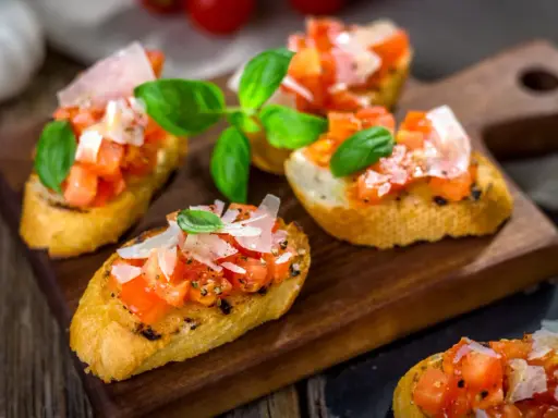 Bruschetta med färska tomater, basilika och parmesan på rostat bröd. Ett enkelt och gott bruschetta recept för alla tillfällen.
