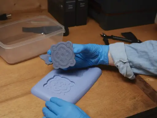 Manos enguantadas muestran un molde de silicona recién hecho, demostrando cómo hacer moldes de silicona para crear piezas decorativas.