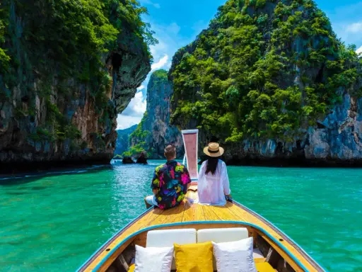 Para w łodzi podziwia turkusową wodę i skaliste wyspy. Idealna pogoda na Phuket w grudniu.