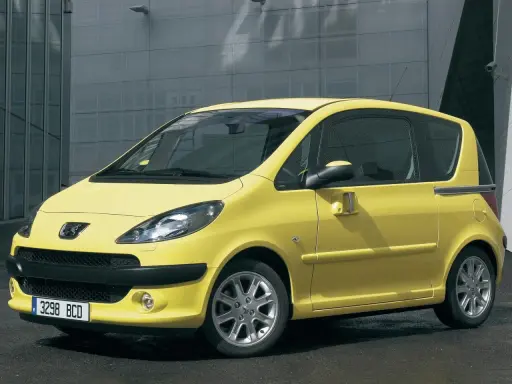 Żółty Peugeot 1007 z przesuwnymi drzwiami stoi przed nowoczesnym budynkiem.