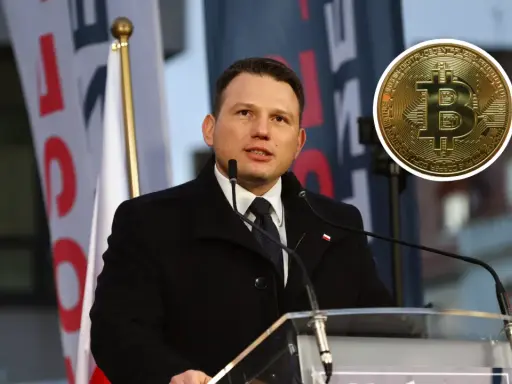 Sławomir Mentzen przemawia, a obok niego widnieje złoty symbol bitcoina, sugerując jego zainteresowanie kryptowalutami.