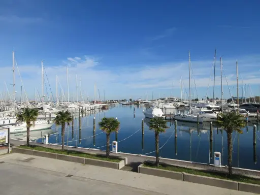 Porto turistico di San Giuliano Mare, Rimini, con barche a vela e yacht ormeggiati in un mare calmo sotto un cielo azzurro.