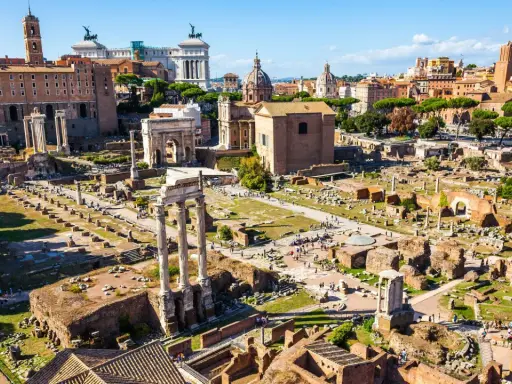 Antike Ruinen des Forum Romanum in Rom, 753 v. Chr. gegründet, mit Säulen, Bögen und Gebäuderesten unter blauem Himmel.