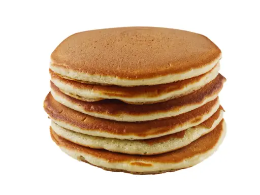 Pile de pancakes dorés faits maison avec de la farine complète, prêts à être dégustés.