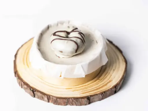 Deliciosa tarta de oro, cubierta de blanco y decorada con chocolate. Presentada sobre una base de madera rústica.