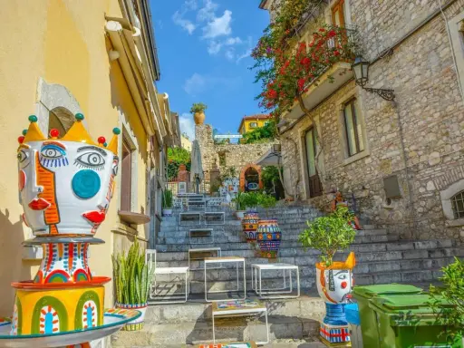 Colorate ceramiche artistiche adornano una scalinata a Taormina, un luogo incantevole per famiglie con bambini.