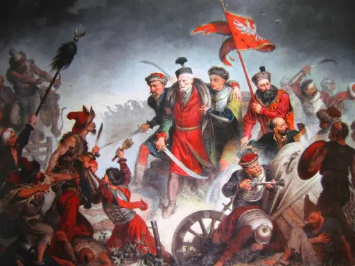 Obraz przedstawia zaciętą bitwę pod Kłuszynem 1610. Polscy żołnierze walczą z wrogiem, wznosząc sztandar z orłem.