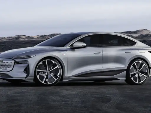Silberner Audi A4 e-tron, ein elegantes Elektroauto, steht vor einer felsigen Küstenlandschaft.