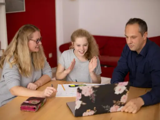 Familie lernt gemeinsam. Die Tochter freut sich über Fortschritte. Nachhilfe Preise pro Stunde sind hier gut investiert.