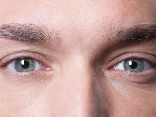 Gros plan sur les yeux d'un homme, mettant en valeur la forme naturelle de ses sourcils.