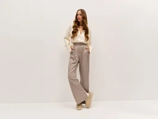 Elegancka kobieta w luźnych spodniach i koszuli. Lyocell: wady i zalety tego materiału w modzie.