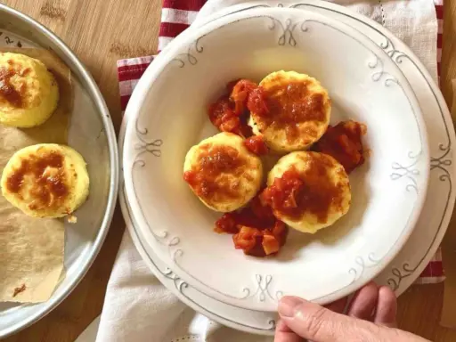 Gnocchi alla romana dorati e gustosi, serviti con un sugo di pomodoro saporito.