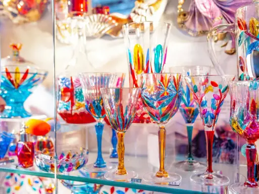 Verrerie colorée et artisanale, un aperçu du musée du verre Murano. Des coupes et verres aux motifs floraux et géométriques éclatants.