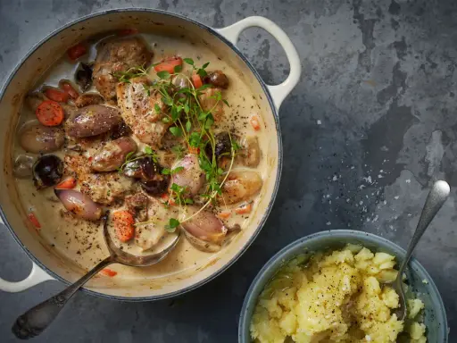 En krämig snabb kycklinggryta med schalottenlök, morötter och svamp, toppad med färsk timjan. Serveras med en skål potatismos.