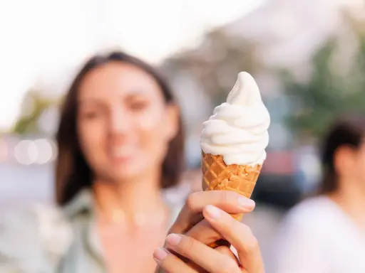 Kobieta trzyma lody na ból gardła. Słodka ochłoda w upalny dzień.