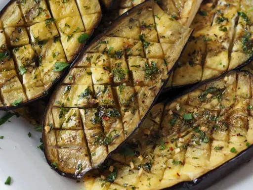 Gegrilltes Gericht mit Aubergine, gewürzt mit Kräutern und Knoblauch.