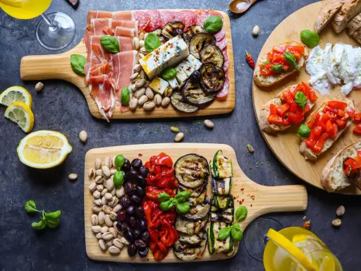 Ein köstlicher italienischer Abend mit Aufschnitt, Käse, gegrilltem Gemüse, Bruschetta und Pistazien. Perfekt für Genießer!