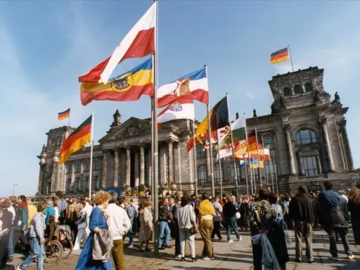 Många flaggor vajar framför Riksdagshuset i Berlin, en symbol för nationell stolthet och nationalismens betydelse.