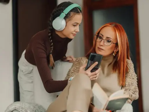Matka z córką omawiają zasady w domu dla nastolatków, patrząc na telefon.