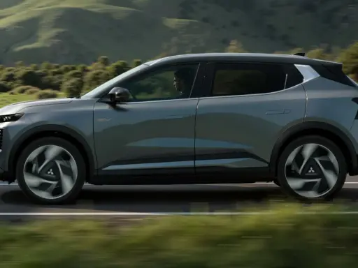 Nowy, elektryczny Mitsubishi Eclipse Cross sunie po malowniczej drodze, otoczony zielonymi wzgórzami.
