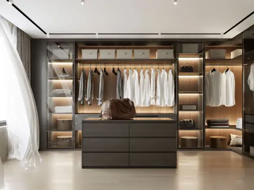 Un dressing moderne et organisé, parfait pour savoir comment ranger son dressing. Chemises blanches suspendues, tiroirs sombres et sacs en cuir.