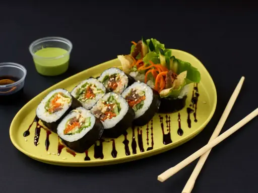 Kimbap-Röllchen mit Gemüse und Fleisch, serviert auf einem gelben Teller mit Sojasauce und Dip. Ein leckeres Kimbap Rezept zum Nachmachen.