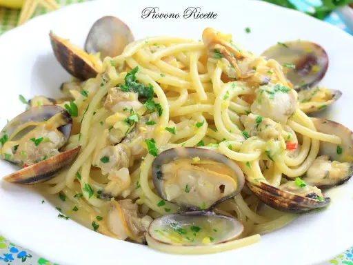 Spaghetti alle vongole cremosi come al ristorante, un piatto di pasta invitante con vongole fresche e prezzemolo tritato.