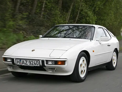 Weißer Porsche 924 fährt auf einer Straße. Der geringe porsche 924 verbrauch macht ihn zu einem sparsamen Klassiker.