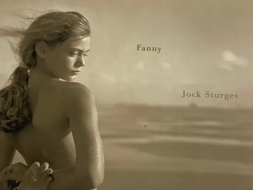 A young woman, Fanny, is captured by Jock Sturges on a beach, her hair blowing in the wind.