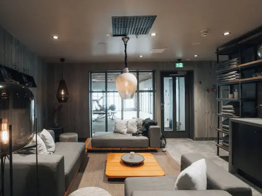 Mysig lounge med soffor och ett gym i bakgrunden på Niehku Mountain Villa.