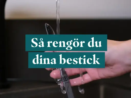 En hand håller ett bestick under rinnande vatten. Texten "Så rengör du dina bestick" visas.
