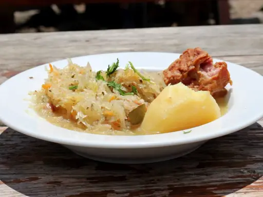 Danie z restauracji Bacówka: ziemniaki, kapusta kiszona z marchewką i kawałek mięsa. Pyszne, tradycyjne danie z menu.