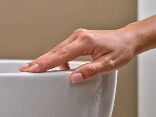 Eine Hand streicht über eine weiße Oberfläche. Mögliche Keratect Nachteile könnten hier eine Rolle spielen, wenn die Oberfläche empfindlich ist.