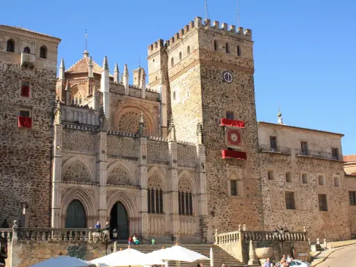 Impresionante catedral en Cáceres, con niños disfrutando de la plaza.