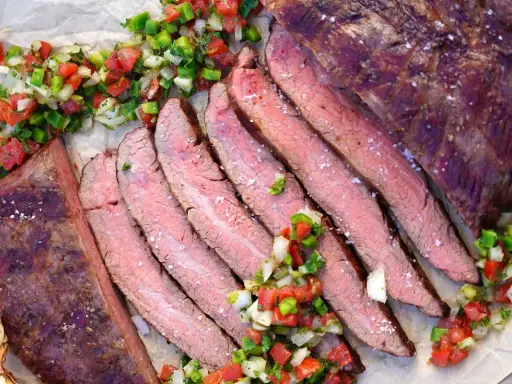 Saftiges, in Scheiben geschnittenes Flank Steak Deutsch, garniert mit frischer Salsa.