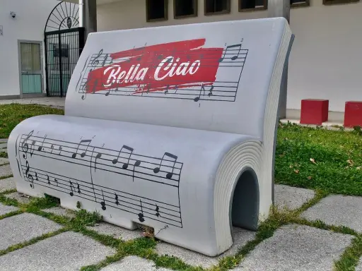 Ławka w kształcie książki z nutami i napisem "Bella Ciao". To symbol wolności i oporu, który znaczy "żegnaj piękna".