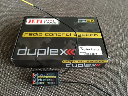 Jeti Duplex Rsat 2 Satellitenempfänger und die Verpackung des Jeti Duplex 2.4EX Funksystems.