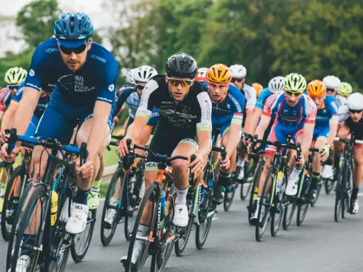 Ciclisti in gara, concentrati e determinati, seguono le loro tabelle allenamento ciclismo per raggiungere la vittoria.