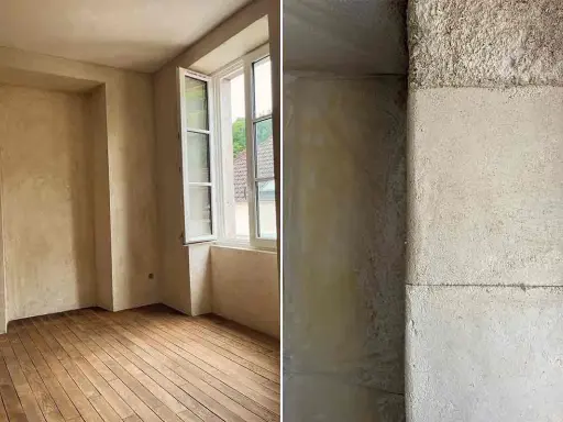 Intérieur d'une pièce aux murs enduits de chaux liège, avec un parquet en bois brut. Gros plan sur la texture rugueuse d'un mur en chaux liège.