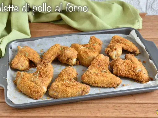 Alette di pollo al forno dorate e croccanti, guarnite con rosmarino fresco, pronte per essere gustate.